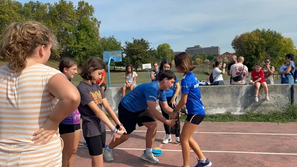 Entrenador de Bihotz Aratz ayudando a una atleta a estirar en la jornada de puertas abiertas